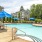 a swimming pool with chairs and umbrellas next to it
