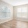 a room with a wood floor and a window with blinds