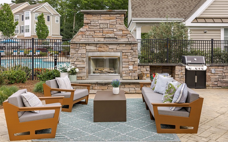 outdoor resident lounge with couch chairs and fireplace
